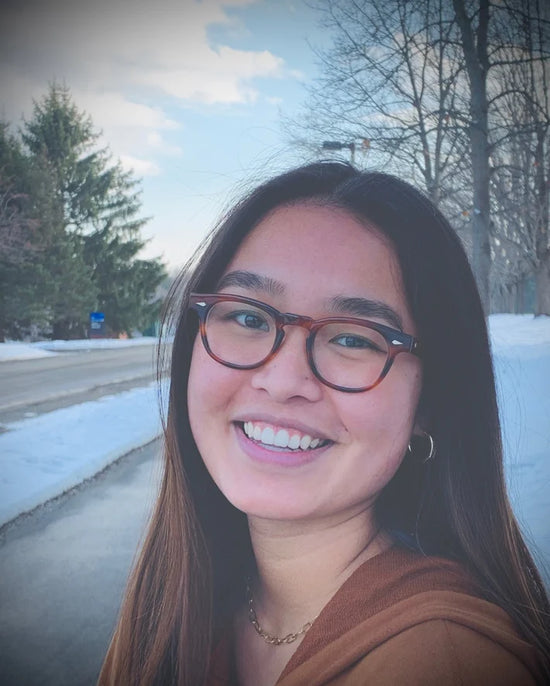 A person with snow behind them wearing Tart Optical's classic eyewear.