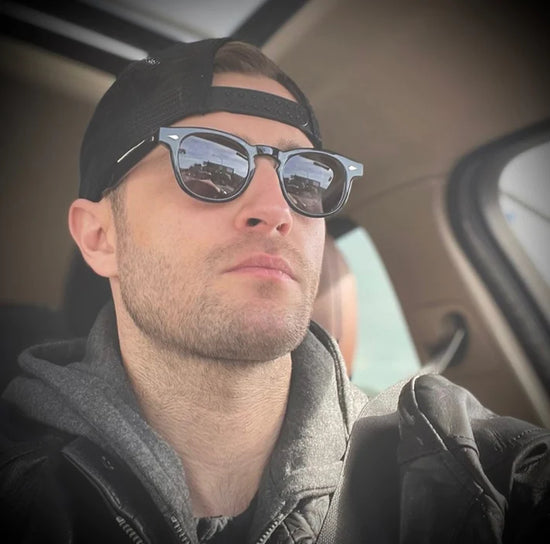 A person in a car wearing Tart Optical's frames.